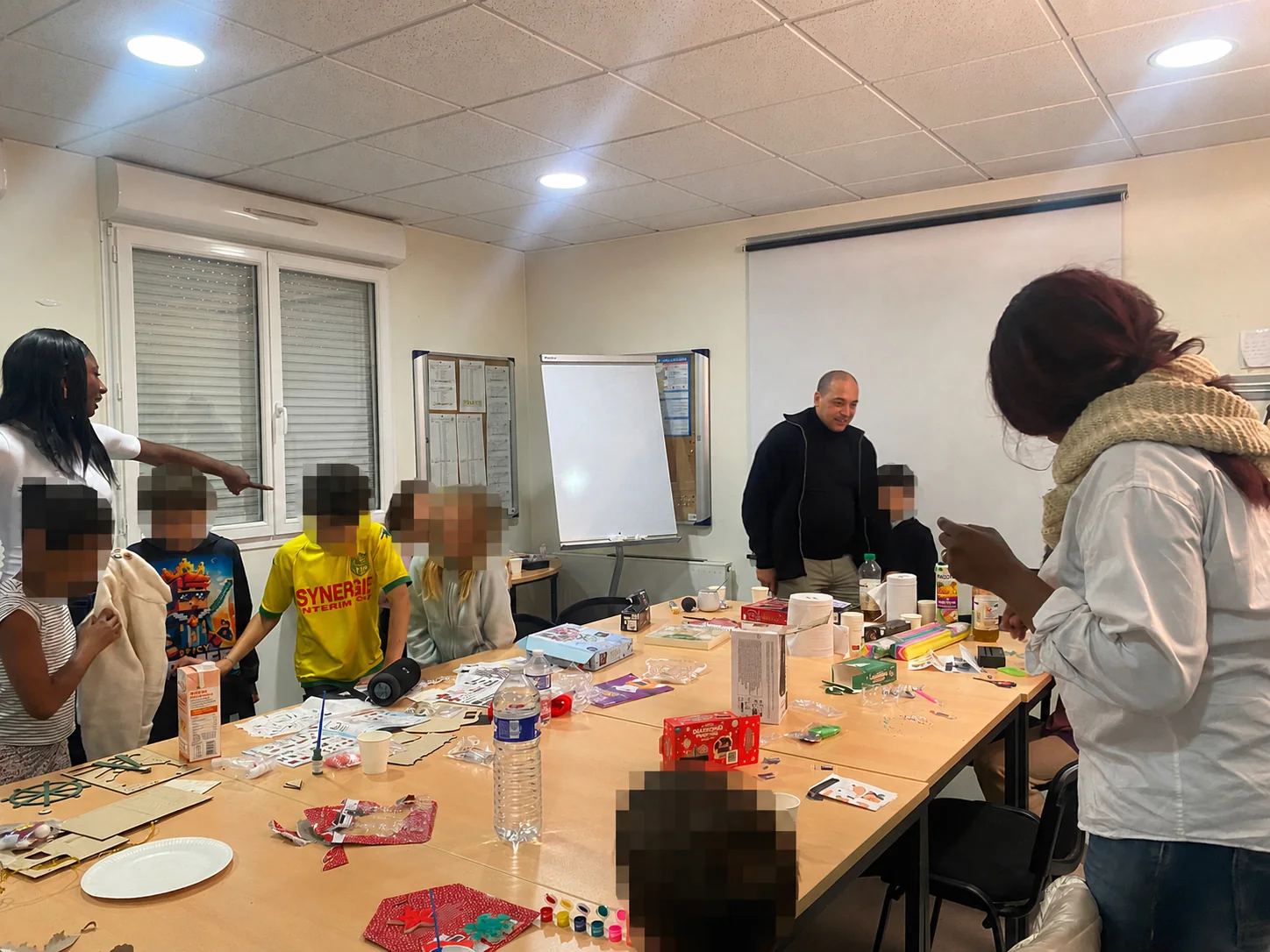 Enfants participant à un atelier manuel ; chaque visage d’enfant est fortement anonymisé