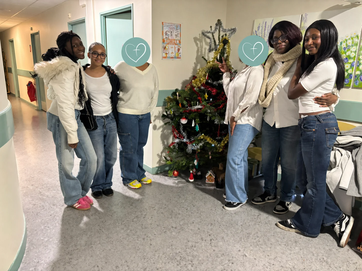 Équipe ALENA’S FAITH près du sapin ; deux adultes sont protégées par les médaillons de la Fondation