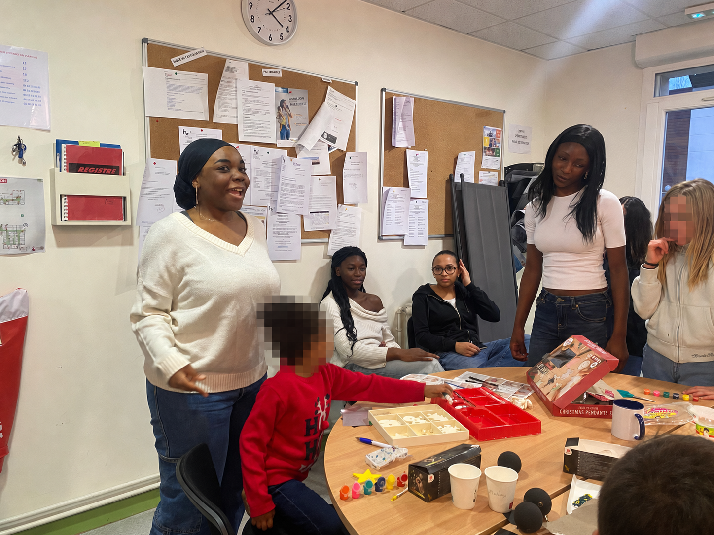 Une responsable d’ALENA’S FAITH accompagnant chaleureusement un enfant lors d’un atelier de la fondation